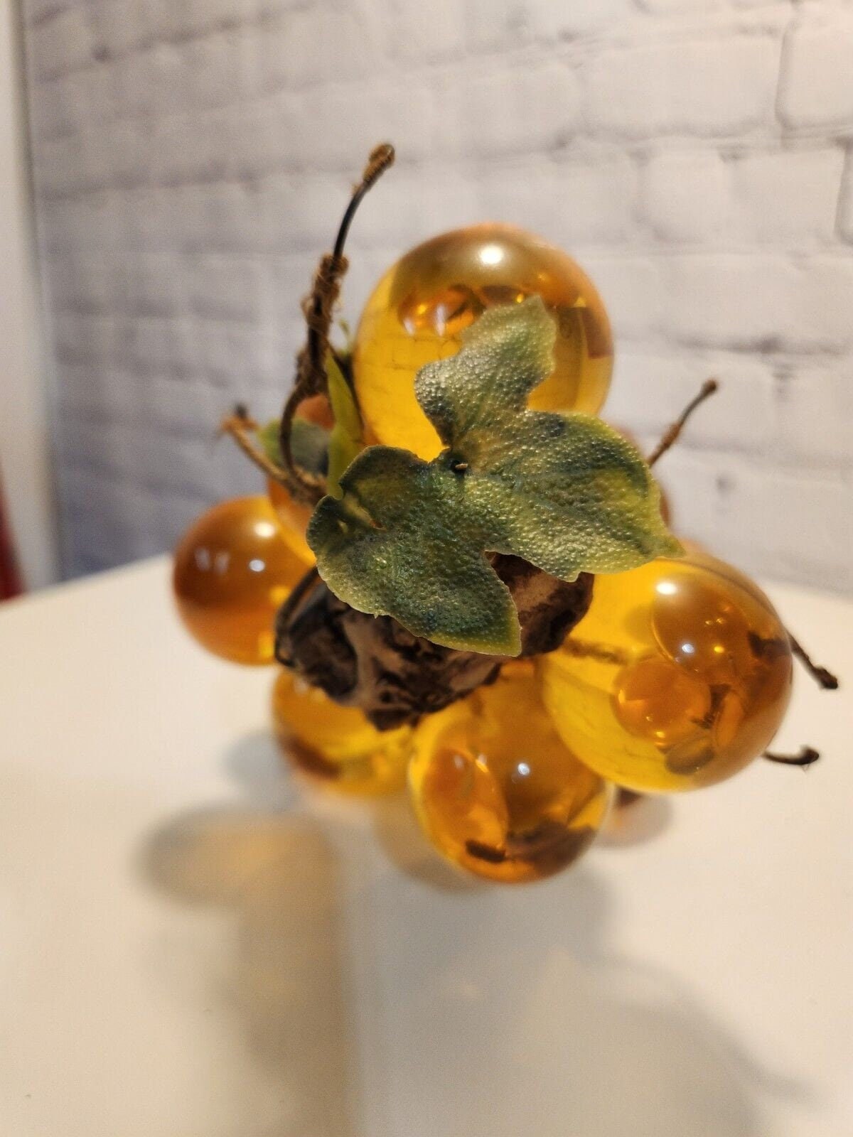 Vtg mcm cluster of large amber honey  lucite acrylic grapes  with plasThis vintage mid-century cluster of large amber honey lucite acrylic grapes with plastic leaves is a timeless piece of art that will add a touch of elegance to any sChas Vintage Shoplarge amber honey lucite acrylic grapes